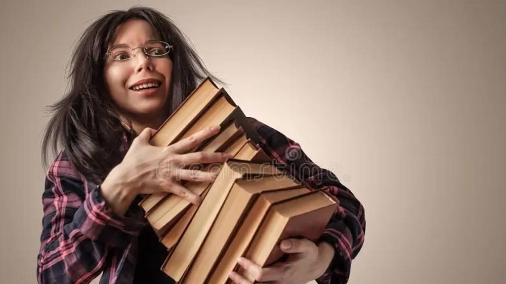 female carying books while smiling